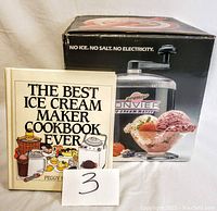 Photo of the recipe book titled 'The Best Ice Cream Maker Cookbook Ever' alongside the ice cream maker box showing the product image and slogan 'No Ice. No Salt. No Electricity.'
