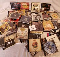 Pile of assorted rock CDs including Guns N' Roses Appetite for Destruction, Foo Fighters, Rolling Stones, Beatles, Green Day, AC/DC, REO Speedwagon, Johnny Cash, Bon Jovi, Pure Cult, Jane's Addiction.