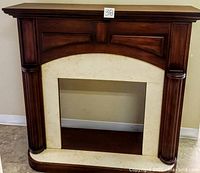 Front view of the fireplace mantle showing the wood and marble combination, carved columns and panel details.