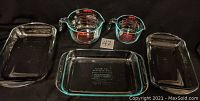 Photo showing all five glassware items together: two 9x13 inch Pyrex baking dishes, one 9x12 inch Anchor Hocking baking dish, and two measuring bowls (1L and 2L) with red markings.