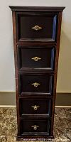 Front view of tall wooden stand showing five framed drawers with brass-finish ring pull handles
