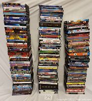 Stacked DVDs showing a large quantity (over 170) with varied movie genres including classics and action films.