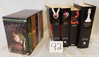 Photo showing the Twilight series boxed set and A Song of Ice and Fire boxed set side by side, highlighting the book titles and box designs.