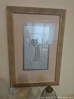 Full view of framed silver toned engraved artwork of a woman with flowers in a textured gold frame.