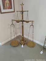 Front view of entire brass scale with two-tier pans and bulls head finial