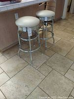 Pair of chrome barstools side by side near kitchen island