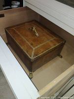 Top view of the closed wooden decorative box showing metal handle and claw feet.