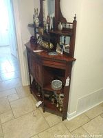 Side-angle view showing full height mirror gallery, top shelf, drawer, painted panel doors, turned legs