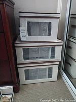 Three stacked fabric cases containing crystal glasses visible through windows