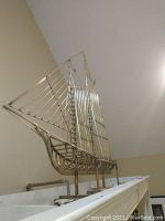 Front view of the brass ship sculpture on its base