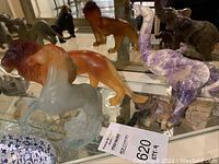 Overview of all four figurines displayed on glass shelf