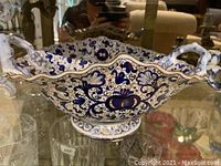 Blue and white decorative bowl with intricate floral patterns and handles