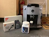 Full lot overview showing machine, frother box, cleaning tablets pack and descaling tablets tub