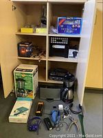 Shelf display showing cutlery, napkins, cups, beacon lamp, plastic snakes, insect killer and appliances