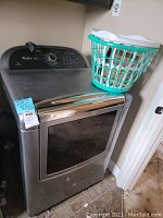 Front-angle view of dryer with laundry basket on top