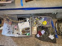 View of jewelry items in bins and trays including necklaces, earrings, and bracelets spread out on carpet