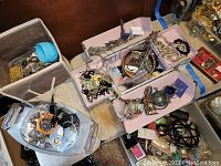 Photo showing multiple jewelry boxes and containers filled with bracelets, necklaces, and other jewelry items, indicating condition and variety.