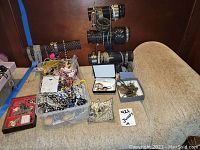 Overview of assorted jewelry including bracelets and rings displayed on multiple black jewelry stands and containers.