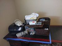 Photo showing HP Envoy 7855 photo printer on desk with power cord and baskets of office supplies including label tapes and ink cartridges.