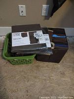 Fabric bins stacked in plastic crate with some still packaged, in brown and blue colors