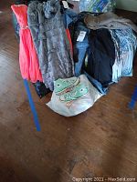 Overview of assorted women's clothing including dresses, tops, jeans, shorts, and shoes.