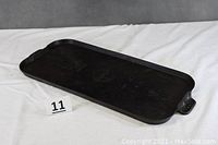 Full view of the large rectangular cast iron griddle showing surface and handles.