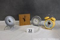 Front wide view of all four clocks staggered in a row showing size and style differences