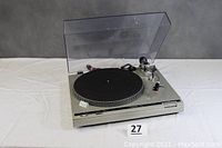 Full view of Technics SL-B2 turntable with clear dust cover raised, black platter mat visible, tonearm on the right.