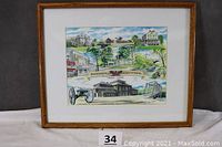 Framed watercolor print with oak frame showing multiple Phoenixville landmarks and sesquicentennial banner.