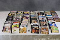 Wide view of approximately 70 assorted music CDs laid out in rows showing a variety of genres including folk, country, big band, hillbilly, yodeling and more.