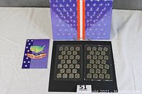 Complete lot including two plastic holders with quarters, a blue display folder and a separate booklet illustrating the 50 states.