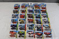 Photo showing all 30 Mattel Hot Wheels cars in their original packaging laid out in 6 rows of 5 cars each on a white background.
