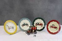 Four metal plates with different colored scalloped edges, each decorated with a vintage car image in the center, shown with the car model in front.