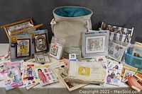 Overview of all craft supplies including magazines, pattern booklets, kits, and large fabric bag.
