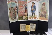 Wide view of all items including two Agricultural Almanacs in center below four vintage seed posters above.