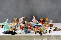 Wide group shot of over 35 assorted Beanie Babies and other stuffed toys arranged on a table including different animals in various poses and colors