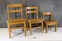 Front view of the three solid oak children's chairs showing size progression from large, medium to small, each with two-slat backrest and solid seats, natural oak finish.
