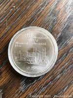 Obverse of the coin showing Montreal 1976 Olympic design with city skyline, Olympic rings, and '10 Dollars' inscription.