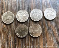Top view showing all six Canadian commemorative dollar coins, each with distinct designs and inscriptions.