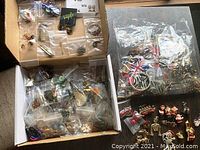 Boxes of assorted earrings and jewelry findings packed in plastic bags and loose