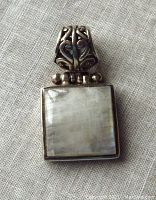 Front view of the sterling silver rainbow moonstone pendant showing the square moonstone set in a bezel with decorative bail.