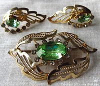 Front view of brooch and earrings showing openwork gold vermeil leaf design and rhinestone settings.