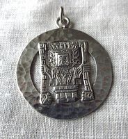 Front view of round sterling silver pendant with Inca tribal figure detail and hammered silver background.