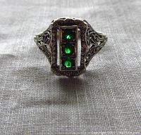 Front view of sterling silver ring showing 3 emerald stones and detailed filigree work on setting.