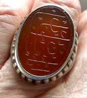 Top view of the oval carnelian stone on the ring showing the engraved tribal-style motifs.