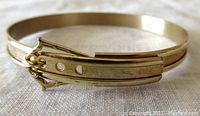 Close-up image of the gold filled child's bangle showing the adjustable buckle clasp and gold finish.
