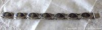Full horizontal view of the entire bracelet showing seven fan-shaped links with black enamel and silver decoration, highlighting the length and style.