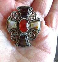 Close up front view showing the detailed Celtic design, stones with different earth-tone colors including central red stone.