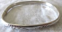 Side view of the rectangular shaped sterling silver bangle showing the engraved detail along the top.