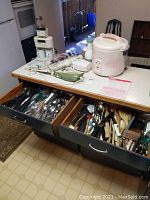 Overview of the lot showing Tiger rice cooker, Philips electric carver, mixers, coffee maker, and open drawers with assorted cutlery